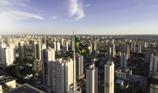 Imagem aérea de prédios e bandeira do Brasil em destaque em Goiânia, alusiva à carteira de fundos imobiliários do Safra de setembro