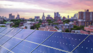 Painéis de energia solar instalados em Nova York, nos EUA, com pôr do sol ao fundo