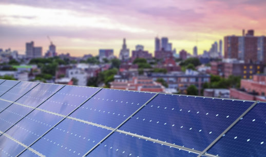 Painéis de energia solar instalados em Nova York, nos EUA, com pôr do sol ao fundo