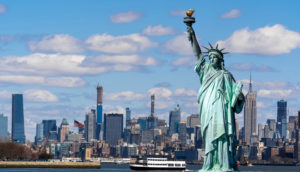 Estátua da Liberdade em primeiro plano com a ilha de Manhattan ao fundo, alusivo ao fato dos EUA de liberar a entrada de brasileiros no país