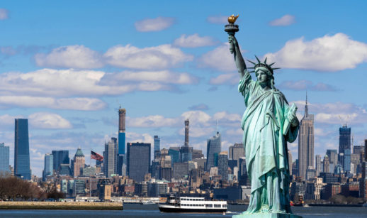Estátua da Liberdade em primeiro plano com a ilha de Manhattan ao fundo, alusivo ao fato dos EUA de liberar a entrada de brasileiros no país