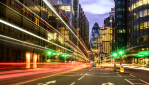 Trânsito com trilha de luz dos carros e o edifício Gherkin, em Londres, ao fundo, alusivo ao Safra Report