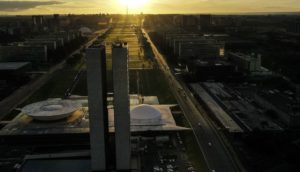 Vista aérea da Esplanada dos Ministérios, em Brasília, de trás do Congresso Nacional, com pôr do sol ao fundo