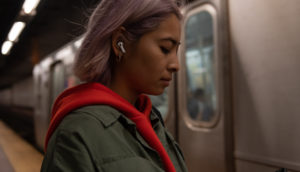 Mulher usando os AirPods Pro, em metrô nos EUA