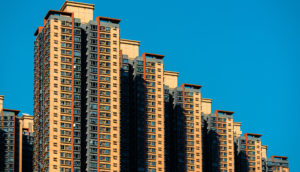 Cinco torres residenciais de Hong Kong, na China, na cor bege e marrom claros, enfileiras em escada, da mais alta, à esquerda, para a mais baixa, à direita, alusivo ao novo imposto imobiliário da China
