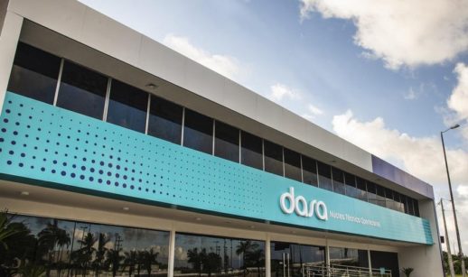 Fachada de prédio da Dasa com destaque para o logo da empresa em faixa azul clara com céu azul em cima