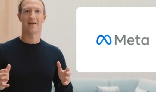 Mark Zuckerberg, à esquerda, com suéter de manga longa preta, com os braços abertos e logo da Meta, nome da nova empresa que controla o Facebook