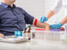 Profissional de laboratório recolhendo sangue de paciente, alusivo às atividades do Grupo Fleury (FLRY3)