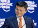Jack Ma, fundador do Alibaba, sorrindo de terno azul e gravata laranja com backdrop atrás com logos do World Economic Forum