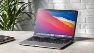 Foto de um MacBook Pro, da Apple, aberto com cores na tela de início