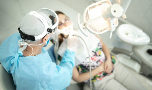 Vista de cima de dentista com aparelhos dentários e paciente deitado, alusivo à Odontoprev