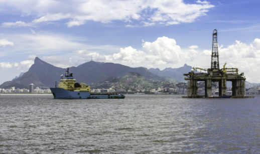 Plataforma de petróleo e navio petroleiro lado a lado com o Rio de Janeiro ao fundo, alusivo à previsão de oferta da Opep para o Brasil