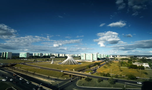 Imagem aérea de Brasília, com a catedral da cidade em destaque com carros em movimento, alusivo ao PIB do Brasil