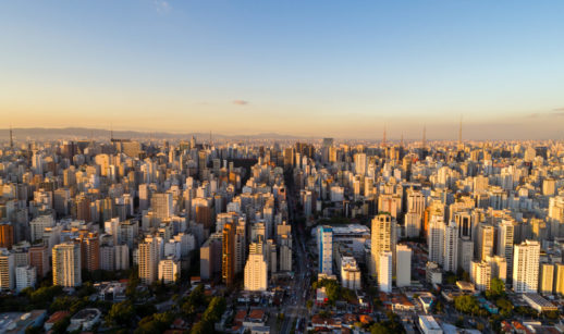 Foto aérea de prédios de São Paulo em meio ao pôr do sol, alusivo ao setor imobiliário