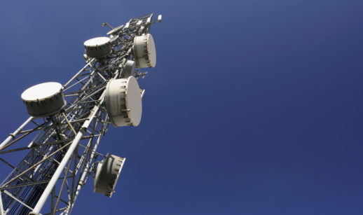 Torre de telecomunicações vista de baixo para cima com céu azul, alusivo à TIM que entrou na carteira de ações com foco em dividendos