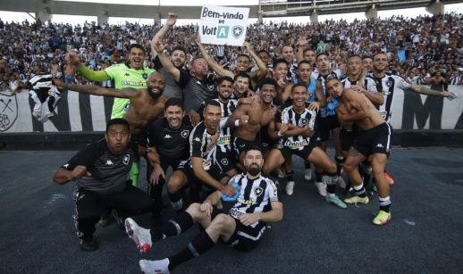 Atletas do Botafogo reunidos em frente à arquibancada com a torcida ao fundo