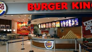 Fachada de loja do Burger King, que anunciou fusão com a Domino's, com destaque para o balcão de pedidos e logo em vermelho em cima