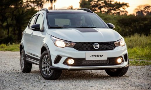 Fiat Argo, líder da lista de carros mais vendidos do Brasil em outubro, na cor branca, de frente parado em estrada de terra e faróis acesos