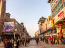 Pessoas andando em rua movimentada de comércio na China