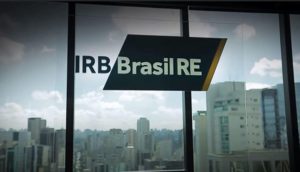Escritório do IRB Brasil RE, com destaque para o logo em vidro com prédios ao fundo