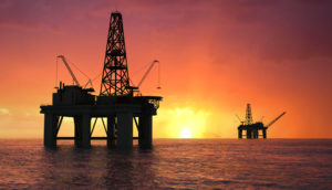 Silhuetas de plataforma de petróleo no mar, alusivo à inflação