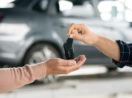Close de mãos de pessoas trocando chaves de carro, alusivo às vendas de veículos