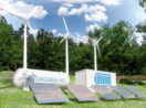 Imagem de tanques de hidrogênio verde com turbinas eólicas atrás