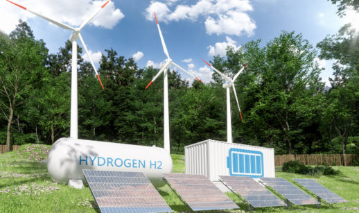 Imagem de tanques de hidrogênio verde com turbinas eólicas atrás