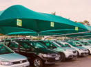 Pátio da Localiza, que vai comprar a Unidas, com carros enfileirados embaixo de toldo verde