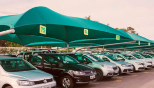 Pátio da Localiza, que vai comprar a Unidas, com carros enfileirados embaixo de toldo verde