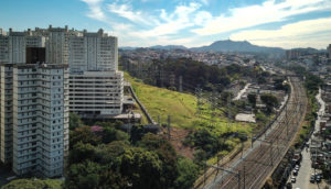 Aérea de linha de trem em São Paulo com torres de transmissão de energia, alusivo à Tarifa Social de Energia Elétrica
