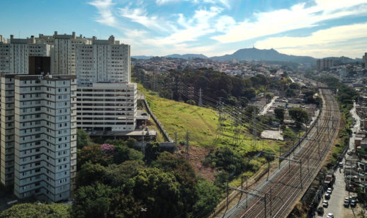 Aérea de linha de trem em São Paulo com torres de transmissão de energia, alusivo à Tarifa Social de Energia Elétrica