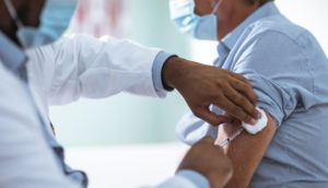 Homem sendo vacinado com a vacina da AstraZeneca contra a cepa ômicron