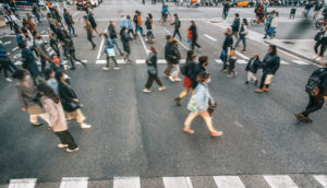 Aérea de pessoas com máscara atravessando faixa de pedestres, alusivo aos novos casos de covid-19 no mundo