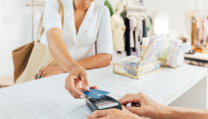 Mulher pagando algo em loja com cartão de crédito no Brasil