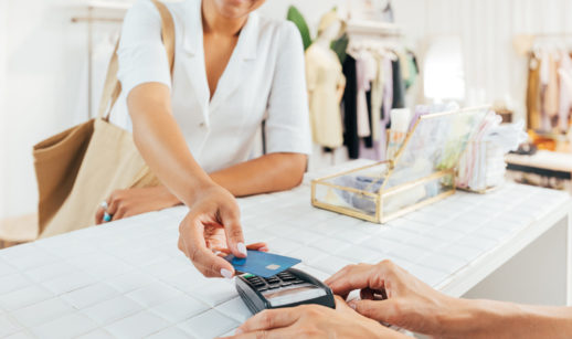 Mulher pagando algo em loja com cartão de crédito no Brasil