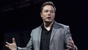 Bilionário Elon Musk, de tenro cinza e camisa preta, durante apresentação