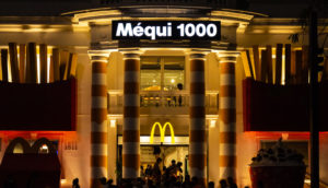 Fachada à noite do Méqui 1000, loja do McDonald's na Avenida Paulista, em São Paulo, com destaque para o letreiro e o logo "M" em amarelo