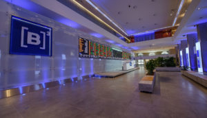 Interior da B3, a bolsa de valores brasileira, que está inserida no mercado de capitais, com destaque para letreiro luminoso e telão com informações sobre ações