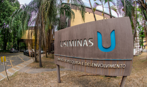 Entrada de unidade administrativa da Usiminas, com placa na frente com logo da empresa e o "U" em azul