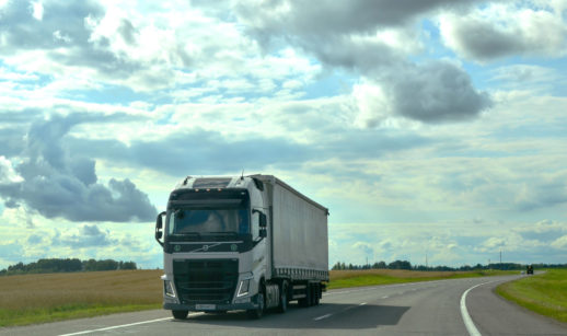 Caminhão na cor branca, da Volvo, andando por estrada com céu azul pouco nublado, alusivo aos investimentos no Brasil