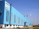 Fachada de unidade da WEG, pintada de azul claro, com destaque para o logo da empresa no canto superior à esquerda, em branco