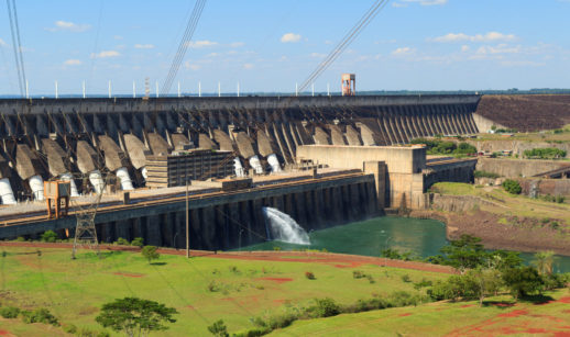 Usina hidrelétrica funcionando em dia ensolarado, alusivo à AES Brasil