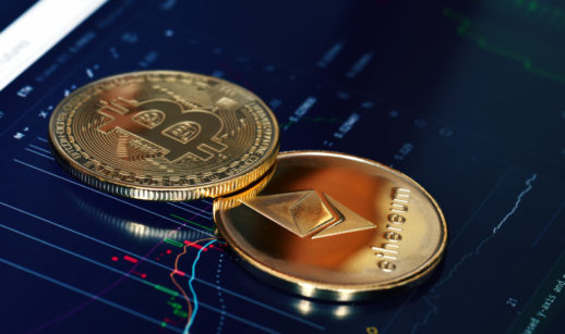 Conceito de duas criptomoedas representando Bitcoin e Ethereum, sobre tela de tablet com gráficos de mercado financeiro