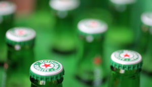 Close sobre garrafas da Heineken, que sairá da Rússia, com destaque para as tampinhas