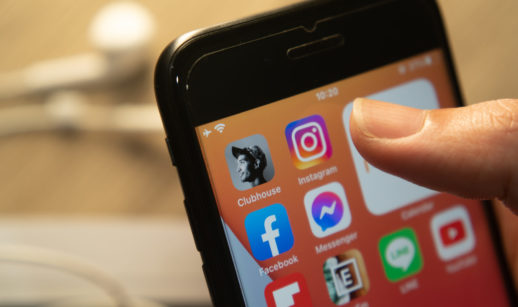 Close de celular com app do Instagram, que deve ter marketplace de NFTs, em destaque e dedo de pessoa próximo