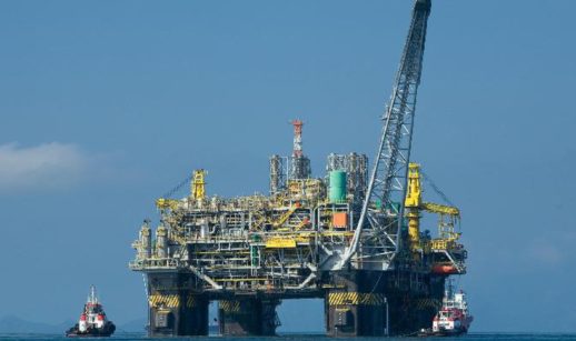 Plataforma de petróleo em alto mar da Petrobras na Bacia de Santos, com céu azul atrás
