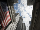 Perspectiva de baixo para cima de prédios de Wall Street, nos EUA, em dia ensolarado