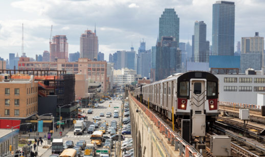 Paisagem do Queens, em Nova York, com metrô passando à direita e carros e táxis abaixo, à esquerda, alusivo à diversificação internacional em renda variável