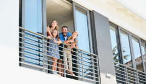 família em varanda de apartamento, alusivo ao seguro residencial
